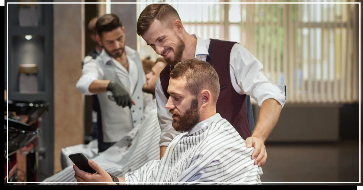 Kažkas trumpai apsikirpęs, sėdintis kirpėjo kėdėje, kalbasi su kirpėju' title=