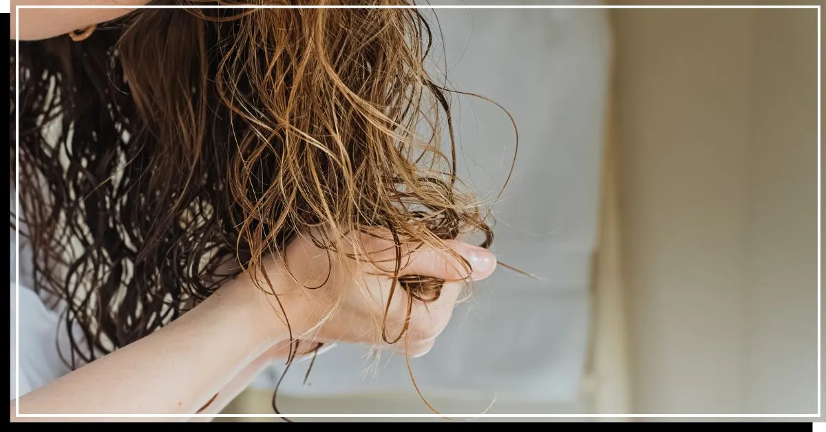 Qualcuno che si arriccia i capelli umidi e ondulati' title=