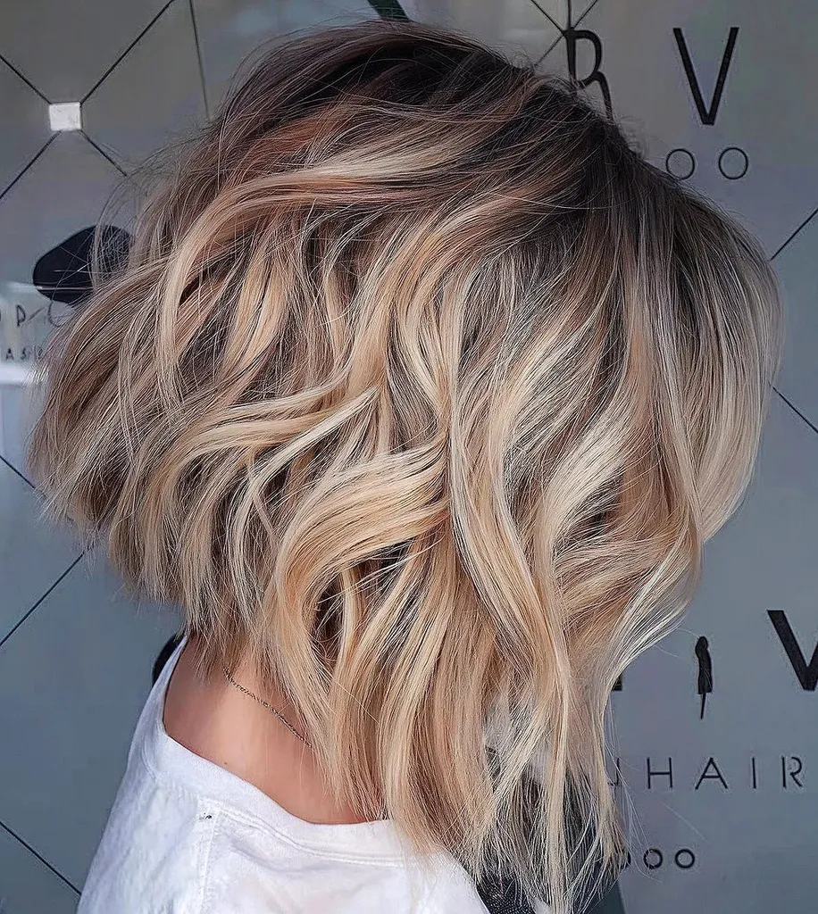 Kurzer, dunkelwurzeliger, blonder, gewellter Bob' title=