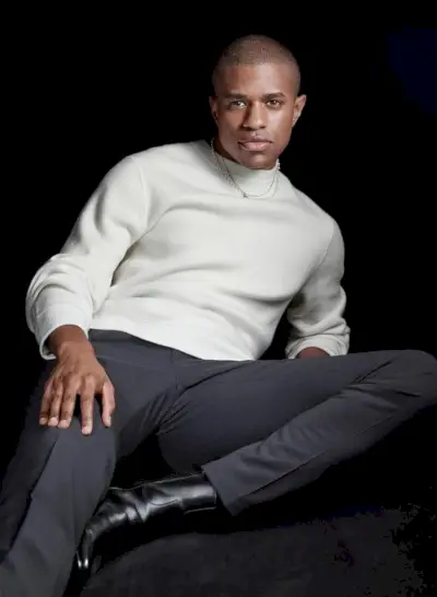 W „Teorii” aktor Jeremy Pope ma na sobie sweter, spodnie i skórzane buty