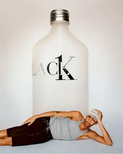 Lucien Clarke posiert vor einer übergroßen Flasche Palace CK1 und ist der Star der Calvin Klein Palace-Kampagne.
