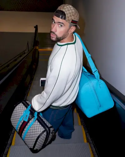 עם כובע לאחור ונושא תיקי דופל יוקרתיים, Bad Bunny מוביל את הפרסומת החדשה של גוצ'י וליגריה.