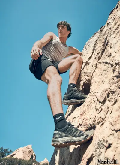 Laipiodamas fizinės treniruotės metu Jacobas Elordis nešioja Hanes tanką su Hiro Clark šortais, Nike kojinėmis ir Salomon sportbačiais.