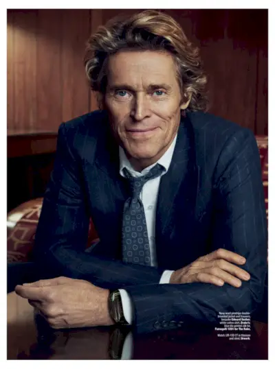 Tout sourire, Willem Dafoe enfile un costume à fines rayures Edward Sexton sur mesure.