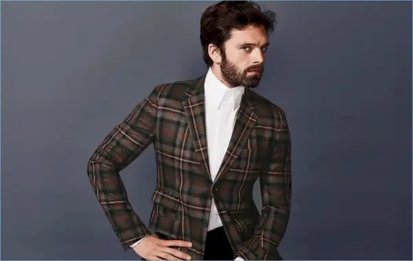 Sebastjans Stens, izceļoties čekos, valkā rūtainu jaku un izteiksmīgu Gucci kleitas kreklu.