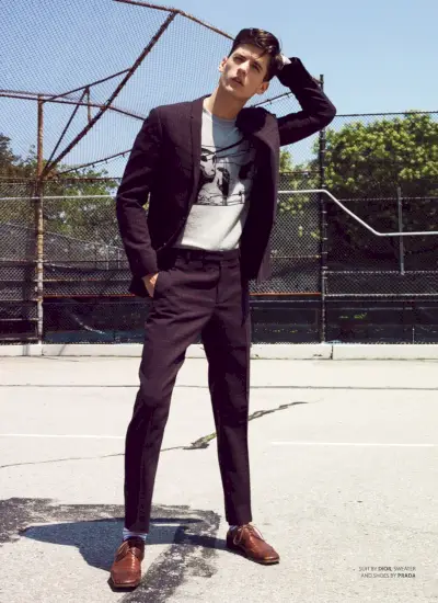 ネイトは Dior Men のスーツ、セーター、靴は Prada を着ています。