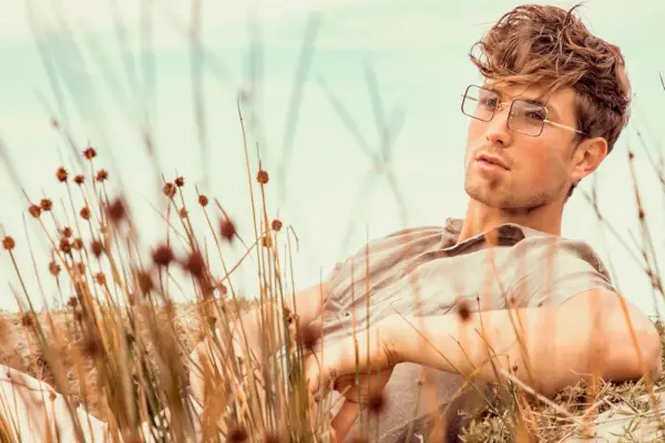 Pour se détendre, Saxon porte une chemise et un pantalon en lin Zara avec des lunettes TVR OPT.