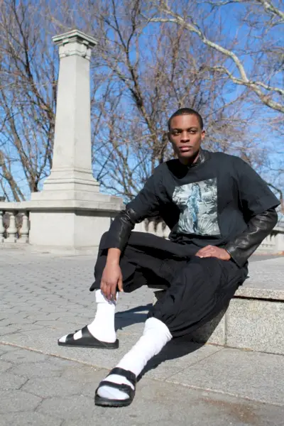 Liam ma na sobie t-shirt Sven Ballenthin, skórzaną kurtkę Emporio Armani, spodnie Alexandre Plokhov i sandały Birkenstock.