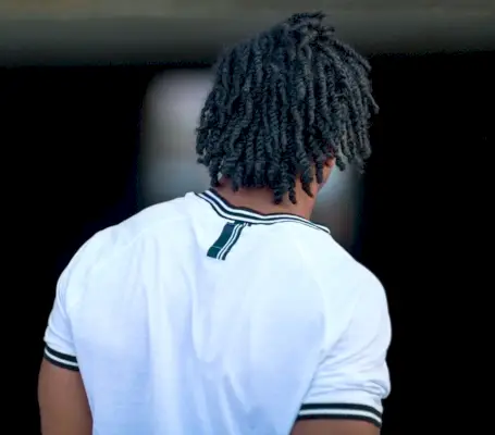 Les hommes aux cheveux longs et bouclés se tordent