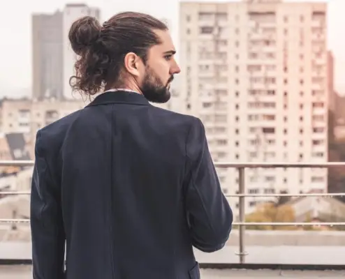 Chignon d'homme en désordre aux cheveux longs et bouclés