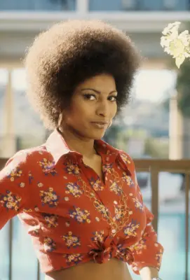 Actor Pam Grier circa 1972, in a red floral shirt and gold chain necklace