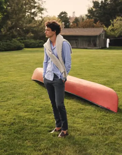 Una visión preppy, Simon Nessman luce un suéter de punto trenzado de cachemir de J.Crew con un pantalón chino elástico de corte entallado 484 y mocasines Camden con suela de cuero.