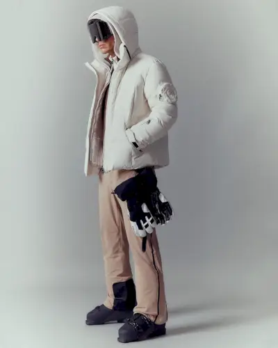 Jivago Santini är förkroppsligandet av elegant vintersportmode i en vadderad Bogner-snödräkt, utrustad med högteknologiska glasögon och skidhandskar, redo för det alpina äventyret.