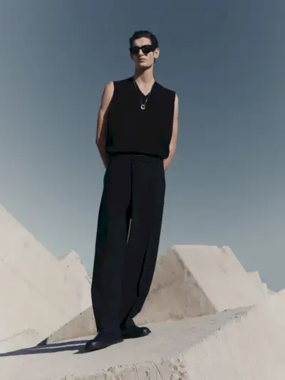 Al frente y al centro, Aaron Shandel luce un chaleco de punto con pantalones plisados de la colección Zara Edition primavera-verano 2023.