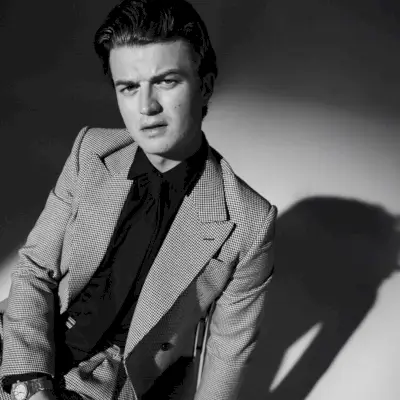 Sotto i riflettori, Joe Keery indossa un abito Alexander McQueen, una camicia Celine, una cravatta Ferragamo e un orologio Audemars Piguet per il WWD Weekend.
