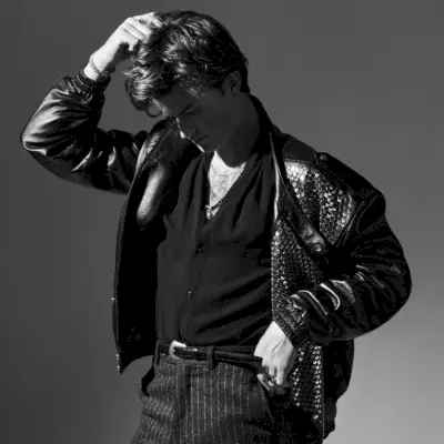 Apparendo in un nuovo servizio fotografico, Joe Keery sfoggia una giacca e una cintura Celine con una camicia Willy Chavarria e pantaloni Bally.