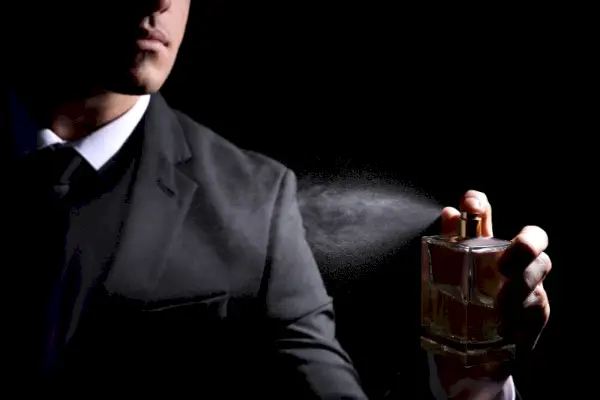 Bărbat care pulverizează costum de colonie