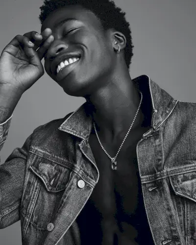 Todo sorrisos, Cheikh Tall modela uma jaqueta jeans Gap.