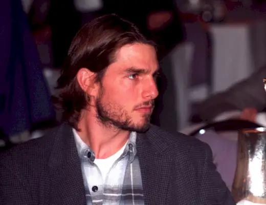 Tom Cruise poartă o cămașă de flanel cu o haină sport, în jurul anului 1992.