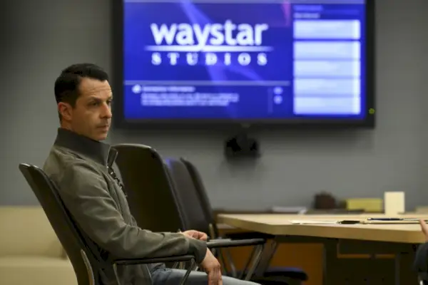 Džeremijs Strongs valkā atturīgu zamšādas jaku, attēlojot Kendalu Roju HBO seriālā Succession.