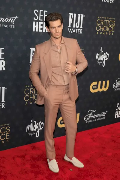 Endrjū Gārfīlds 28. gadskārtējā Critics Choice Awards pasniegšanas ceremonijā izceļas ar vienkrāsainu izskatu. Gārfīlds valkā neitrālas krāsas apģērbu no Zegna ar zamšādas klaipiem.