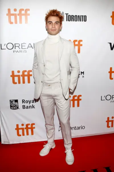 KJ Apa iekļaujas monohromatiskā stilā ziloņkaula Viktora Li uzvalkā ar elegantu bruņurupuču apkakli, apmeklējot Toronto pirmizrādi.