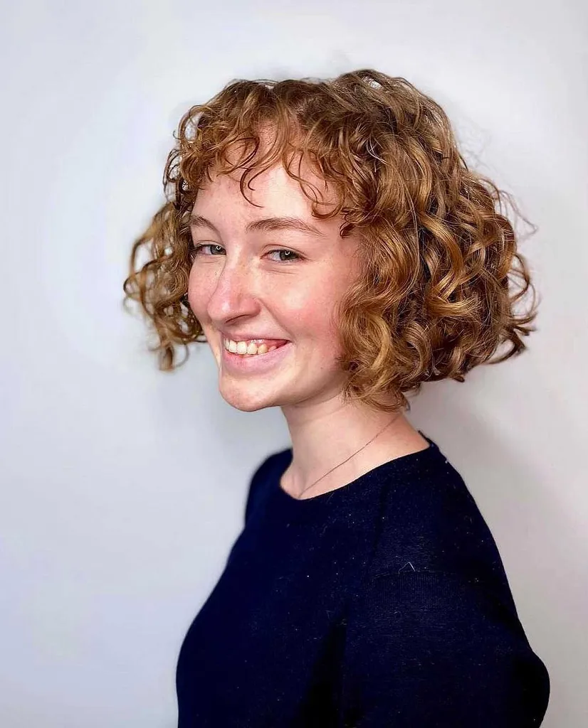 앞머리가 짧은 턱 길이의 곱슬머리 무딘 밥' title=