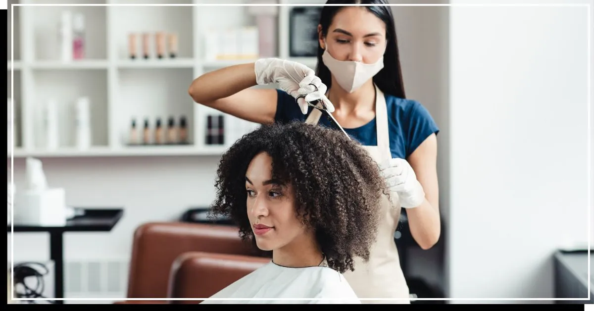 En med krøllet hår bliver klippet' title=