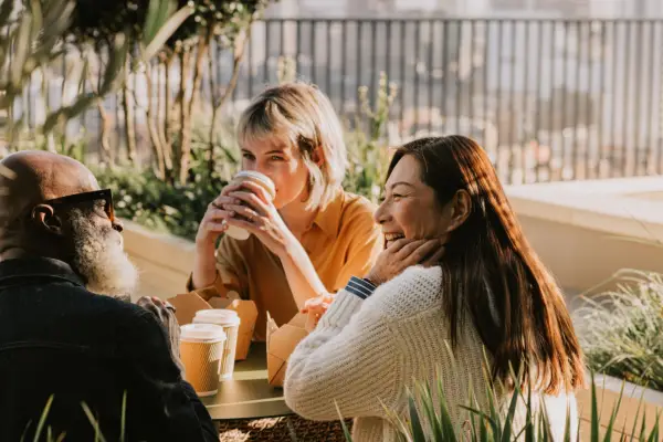 Friends seated around a table drinking coffee