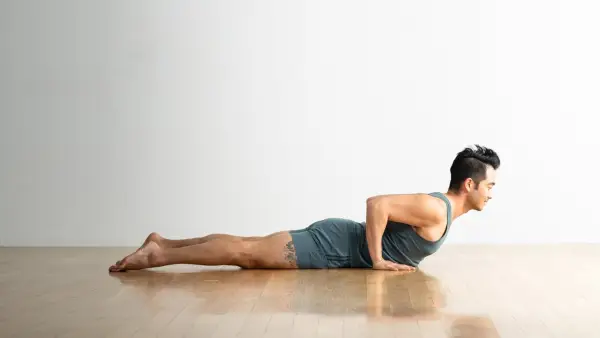 Woman stretching on the floor in orange workout outfit.
