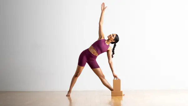 Woman in Extended Triangle Pose variation with hand on block