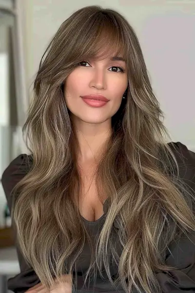 Long layered haircut with side-swept bangs