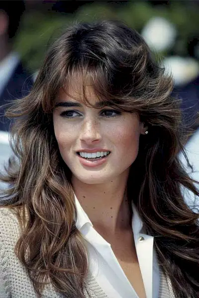 Long, sun-kissed balayage feathered bangs suitable for oval faces, capturing the 
