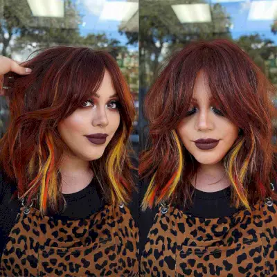 Medium Dark Red Hair with Yellow Peekaboo Highlights and Bottleneck Bangs
