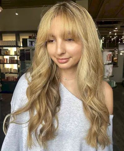Long Wavy Blonde Hair with Grown Out French Bangs