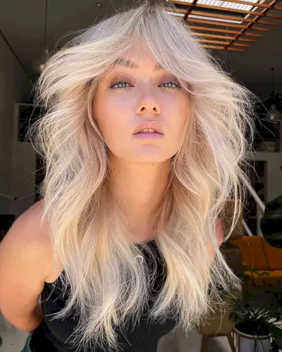 Bright Creamy Blonde Blowout with Long Curtain Bangs and Layers