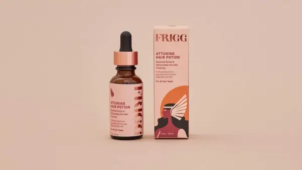Frigg hair potion dropper bottle with packaging on pinkish-tan background