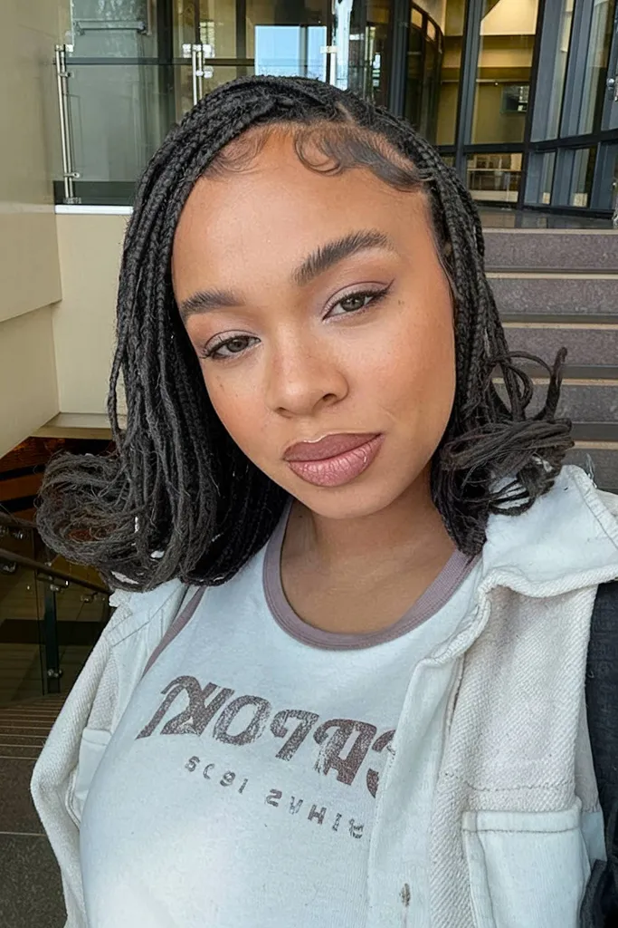 Riccioli francesi lunghi fino alle spalle con trecce nere' title=