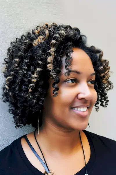 Natural hair with a tapered cut highlighting voluminous tight coils and dimensional highlights