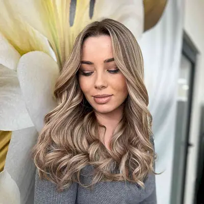 Dark Rooted Curled Dark Blonde Hairstyle with layers and a center part