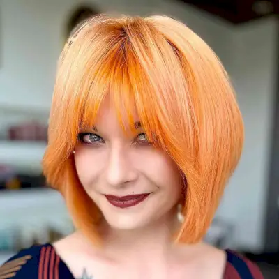 Short Bright Orange Layered Bob with Fringe for women with an edgy style