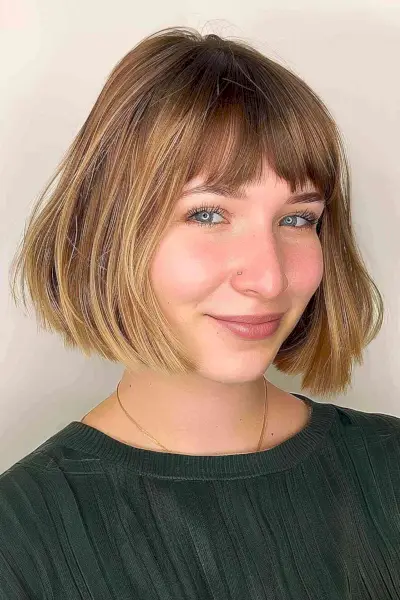 Chin-length rounded bob with fringe and caramel balayage on medium-density hair