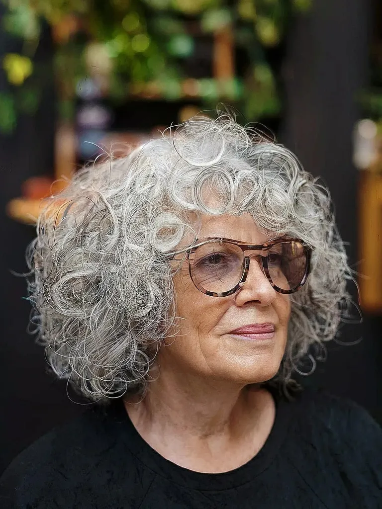 Bob scurt și buclat gri pentru femei peste 70 de ani cu ochelari' title=