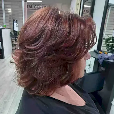 Neck-Grazing Feathered Butterfly Cut for Red Thick Hair