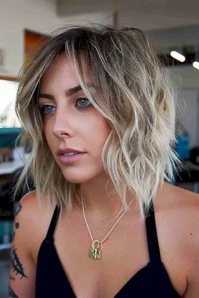 Short platinum blonde bob with textured shaggy layers.