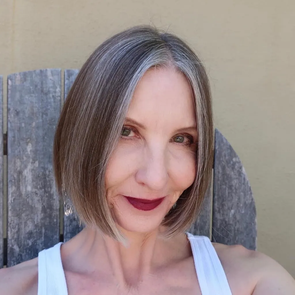 אישה מעל גיל 60 עם שיער קצר ותספורת בוב קהה' title=