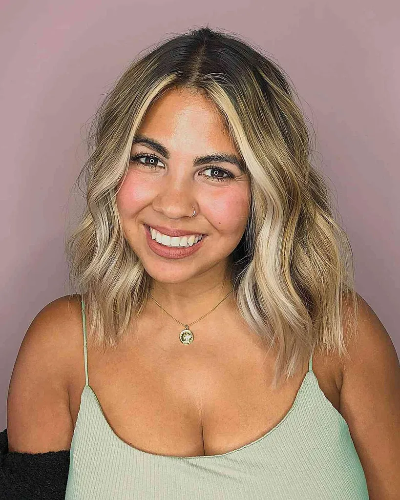 Tamsiai įsišaknijusi blondinė banguota juostelė, skirta plaukams iki pečių ir apvaliems veidams' title=