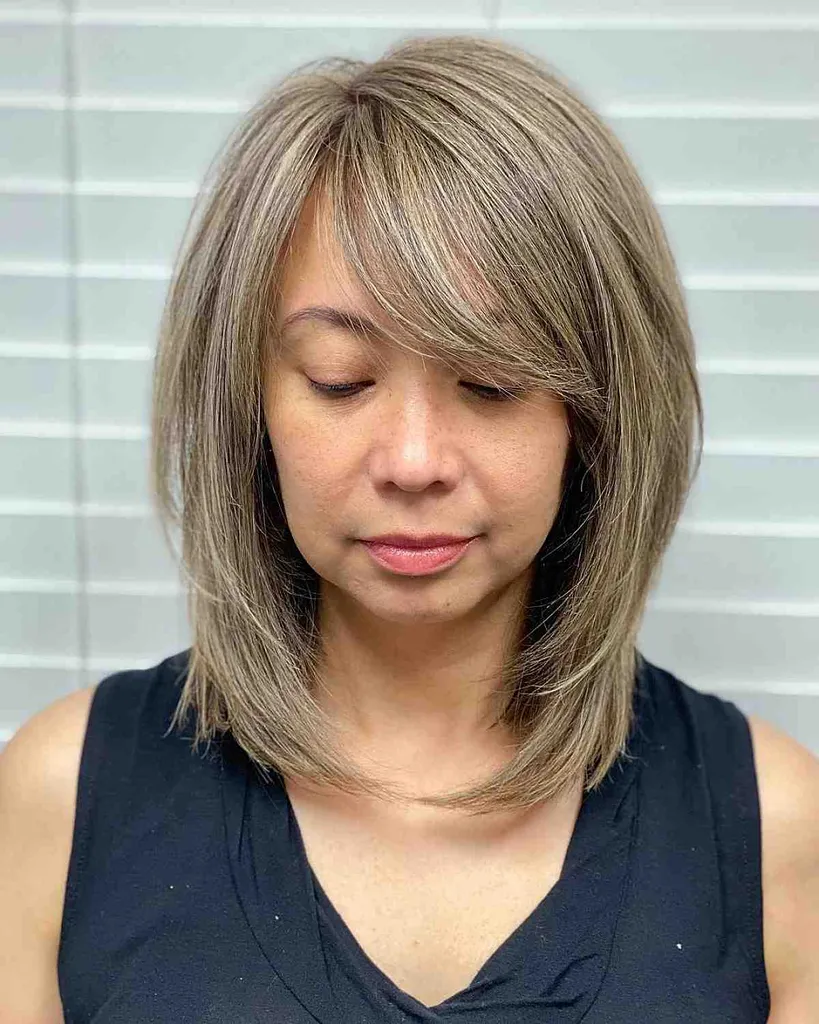 lobis su šoniniais kirpčiukais, skirtas moterims su apvaliais veidais' title=