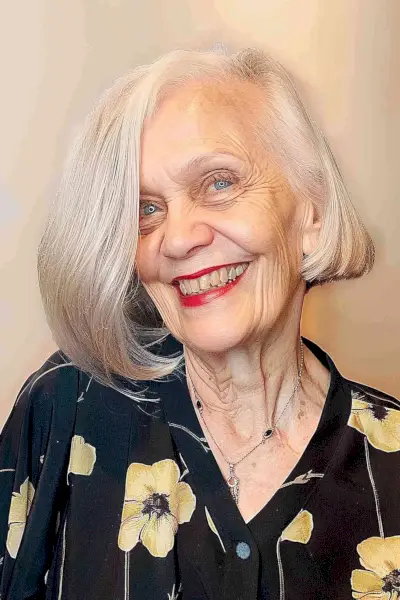 Silver mid-length bob with side-swept bangs for a chic look on women over 70.