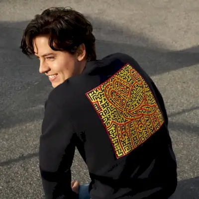 Schauspieler Cole Sprouse trägt ein Coach Disney Mickey Mouse x Keith Haring-Sweatshirt.